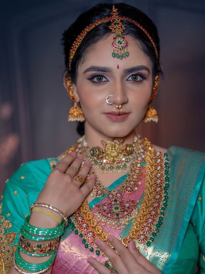 A direct portrait shot that highlights the symmetry and detail of the choker, haram, and maang tikka.