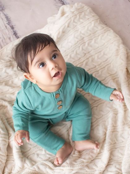 An overhead shot capturing the curious gaze of this sweet six-month-old, taken on a simple, textured blanket to keep the focus on him.