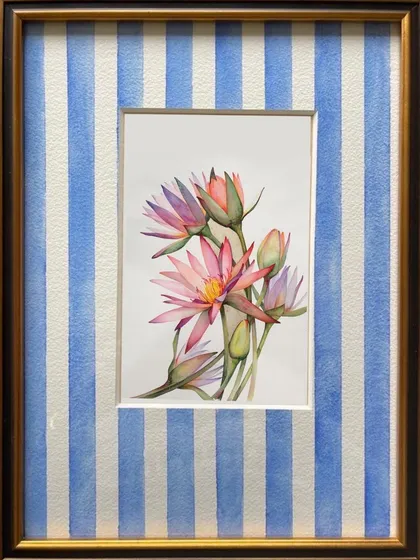 A custom floral painting of water lilies, framed with a hand-painted blue and white striped mount. This experimental framing adds a playful and contemporary touch to the traditional botanical art.