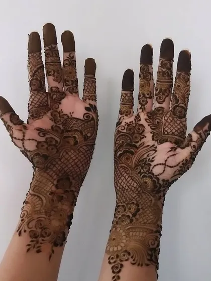 A beautiful example of a semi-full hand design. It features a delicate net pattern on the back of the hand, flowing into more intricate work towards the wrist.