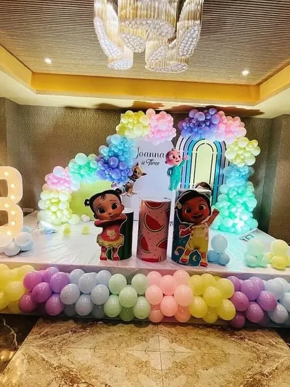 A different view of the pastel Cocomelon stage, highlighting the light-up number '3' and the colorful balloon arrangement.