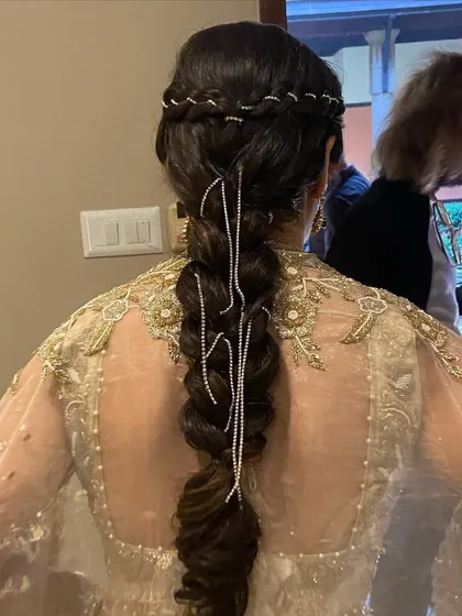 A stunning and intricate braid decorated with hanging diamond chains. This is a very glamorous and unique hairstyle for a sangeet or reception.