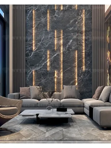 A lobby in Kirti Nagar with a dramatic, dark marble wall featuring integrated vertical lighting. The unique, curved armchair adds a sculptural element to the room.