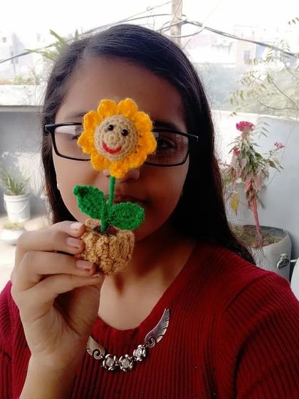 The daughter of our duo holding a mini smiley sunflower pot.