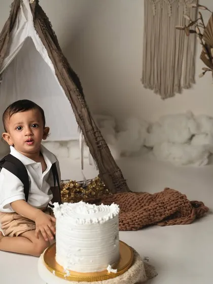The cake has arrived. His curious expression just before the cake smash begins is a priceless moment from his first birthday photoshoot.