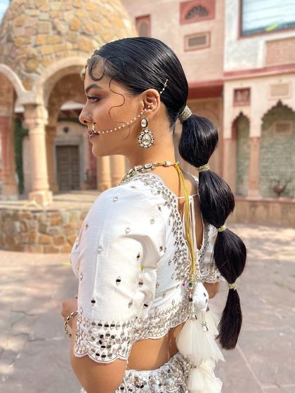 Another view of the bubble ponytail, this time with a traditional nath and maang tikka, showing how modern and traditional elements can be blended.