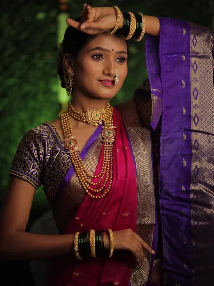 Draped in a traditional Nauvari saree, this bride looks absolutely regal. The pose showcases the beautiful fall of the saree and the elegance of the overall look, complete with green bangles.
