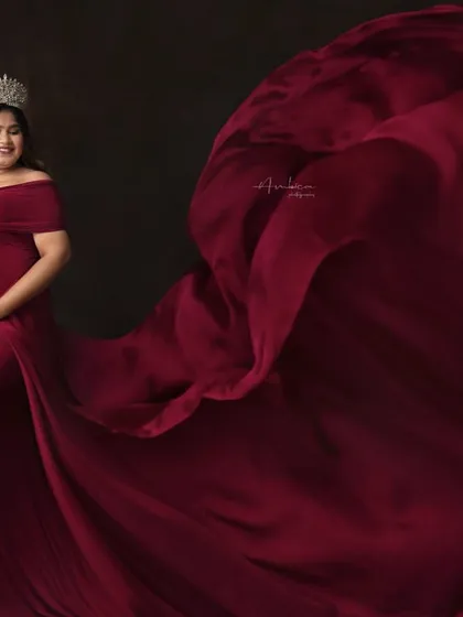 Every mother is a queen. This dramatic studio portrait features a flowing red gown tossed to create a sense of movement and grandeur. The crown adds a final touch of royalty.