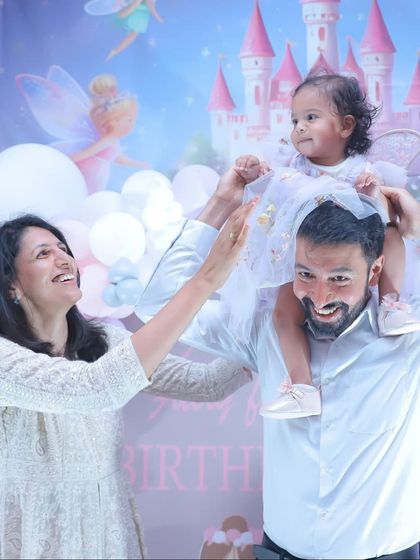 Up on daddy's shoulders, the best seat in the house! These are the playful, happy moments that truly define a family celebration.