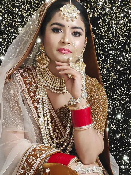 This bride is wearing a stunning layered pearl and Kundan jewellery set with her golden-brown bridal lehenga, creating a regal and sophisticated look.