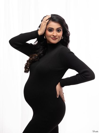 A confident pose that channels a high-fashion vibe. The simple black dress allows your personality and the beauty of your pregnancy to be the main focus.