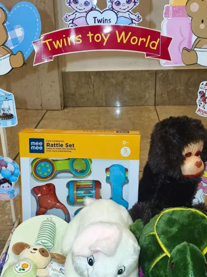 The 'Twins Toy World' cart, loaded with a variety of soft toys and a rattle set for two.
