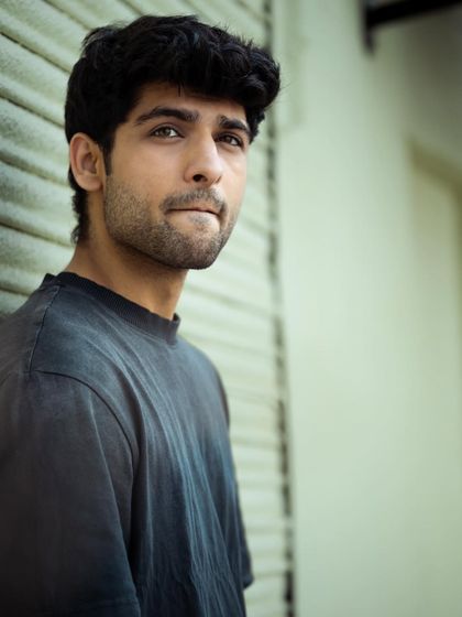 This shot from the same urban series captures a candid, thoughtful moment. The composition and pose are designed to feel natural and unforced, adding a layer of personality to a men's fashion portfolio.