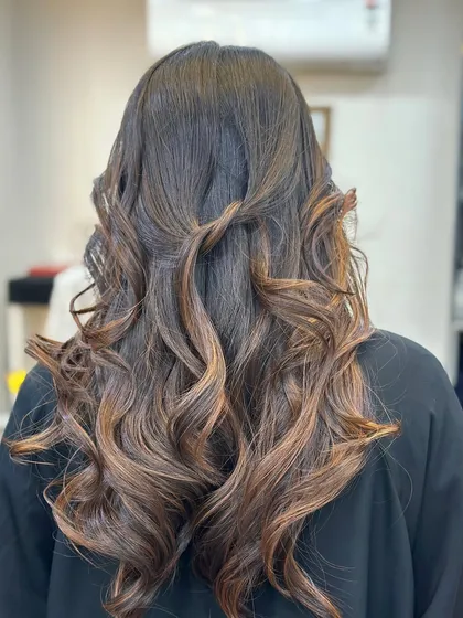 A simple twist adds a touch of elegance to this curly brown hairstyle.