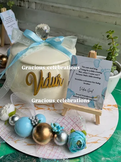 Another look at the details of our baby announcement platter. The custom name cutout, the tiny easel with a sweet message, and the coordinated blue and gold decorations make it a truly special gift.