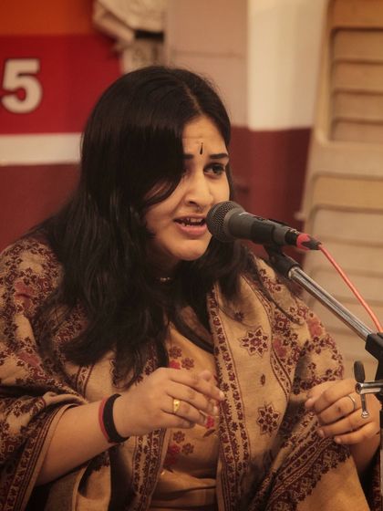 A student engrossed in her bhajan performance, her expression reflecting the soulful nature of the music.