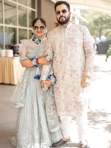 The happy couple at their destination wedding's Haldi ceremony. The bride is wearing my custom blue floral jewellery set.