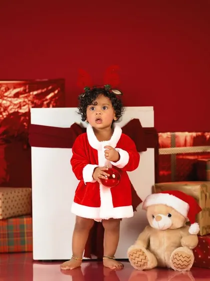 The most wonderful time of the year. This little one dressed as Santa, surrounded by presents, is the definition of Christmas cuteness.
