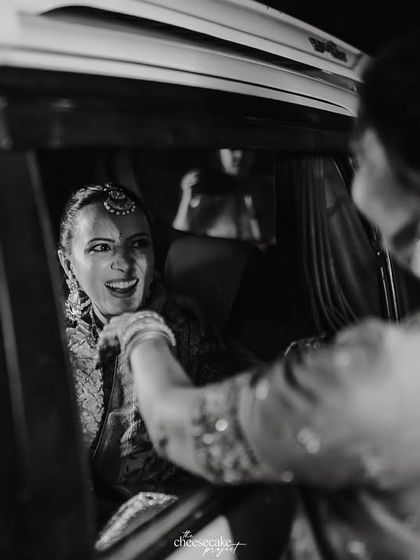 A black and white candid of the bride interacting with her mother one last time before leaving.