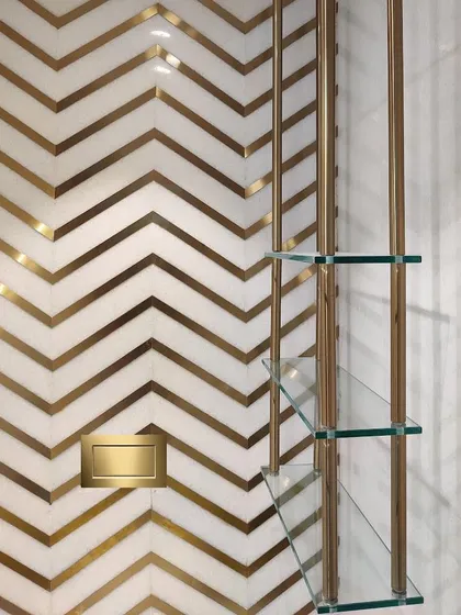 Details make the design. In this powder bathroom, I used a bold chevron pattern with inlaid brass in white marble to create a feeling of pure luxury and drama in a small space.
