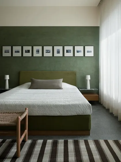 This master bedroom from our Barefoot House project shows our use of layered textures and colours to create tranquility. The deep green lime plaster wall provides a soothing backdrop, making the room a true haven from the city.