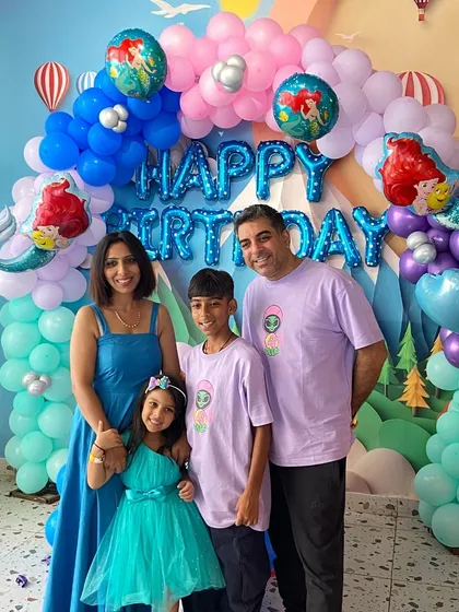 A lovely family photo in front of the Ariel-themed birthday backdrop.
