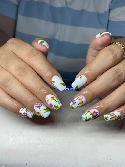 A matte white base with delicate, hand-painted wildflowers. This 'meadow nails' look is artistic and perfect for spring.
