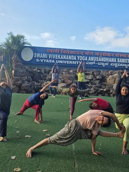 Our team practicing yoga together in front of the iconic sign at SVYASA University in Bangalore. These visits allow us to connect with the academic and research side of yoga.