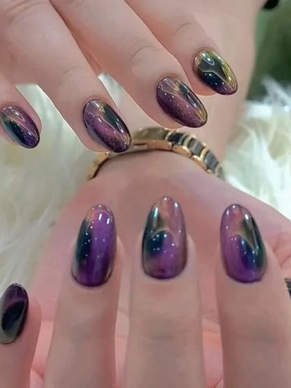 A beautiful galaxy-like effect created with multi-tonal cat-eye polish, showing shades of purple, gold, and black.