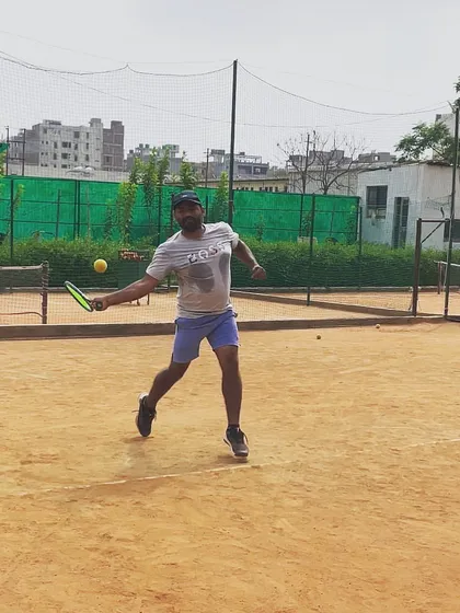 A player caught in action, hitting a running forehand with full commitment.
