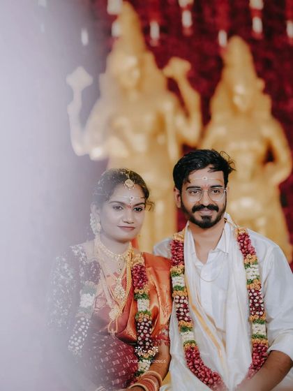 A portrait of the couple seated before the deities, a moment of calm amidst the wedding celebrations.