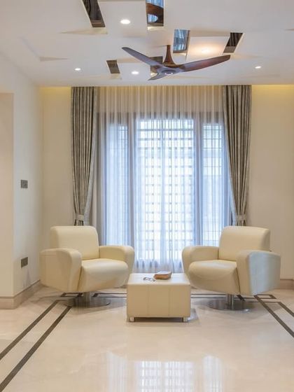 A cozy seating area in the "Chic Adobe" project, featuring comfortable leather armchairs and simple, elegant marble floor inlay.