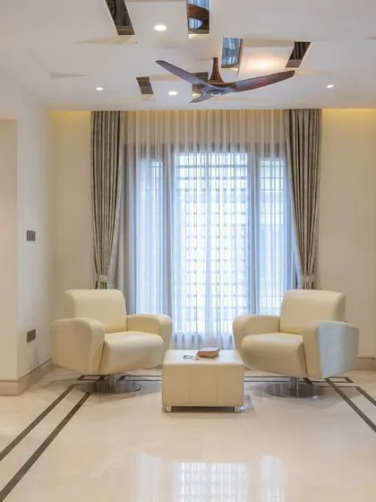 A cozy seating area in the "Chic Adobe" project, featuring comfortable leather armchairs and simple, elegant marble floor inlay.