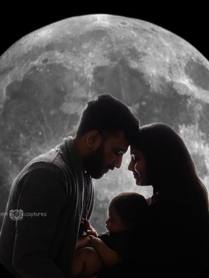 A black and white version of the family silhouette against the moon, emphasizing the form and connection between the parents and their newborn.