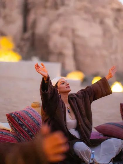 A participant in a state of deep gratitude and openness during our fire ceremony in Al-Ula. The fire element is a powerful purifier, helping us to release what no longer serves us.