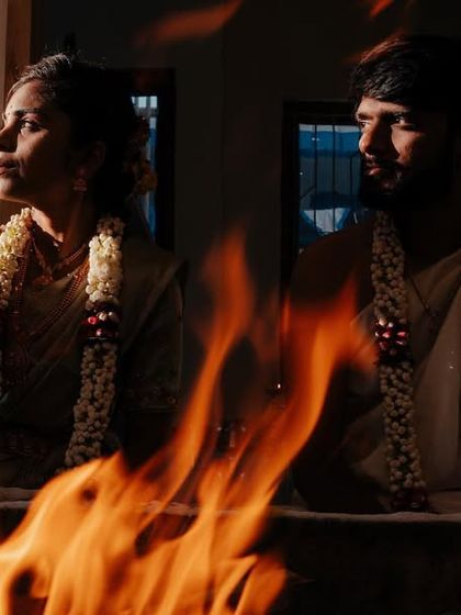A dramatic shot of a couple during a fire ritual, using the flames to create a powerful and atmospheric image.