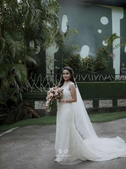 A full-length portrait of the bride in a lush garden, her elegant gown and veil perfectly complementing the natural surroundings.