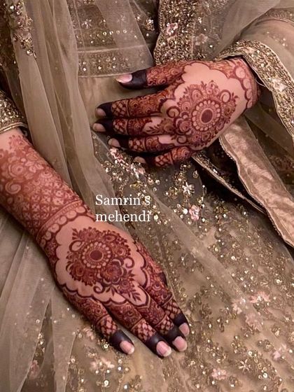 An elegant pose showing the beautiful mandala stain on the back of the hands. The color is rich and even, complementing the bride's stunning outfit.