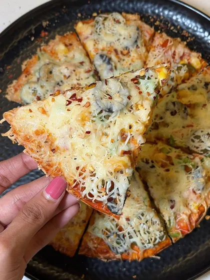 Holding up a slice of my All Veg Pizza, a classic and delicious choice for any pizza lover.