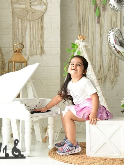 Celebrating a third birthday with a touch of boho elegance. The white piano and macrame wall hangings create a chic and modern rustic look.