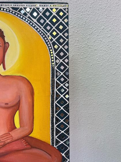 A detailed shot of the corner of the Mahavir Swami painting, highlighting the intricate Lippan and Mandala-inspired border. The small mirrors catch the light, adding a dynamic element to the piece.