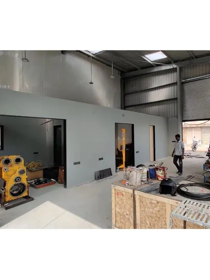 A 'before' shot of the interior during construction, showing the raw warehouse space before the office partitions and finishes were installed.