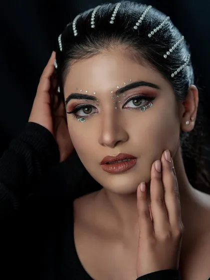 Let's get creative! This high-fashion makeup look with delicate face gems and a sharp winged liner shows a different side of my artistry. It's perfect for photoshoots or for anyone wanting to try something bold and unique.