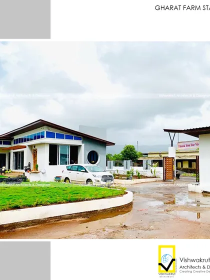 The entrance to Gharat Farm Stay, showing the driveway and the front facade of the building. The design aims to be welcoming while hinting at the modern and nature-centric experience within.