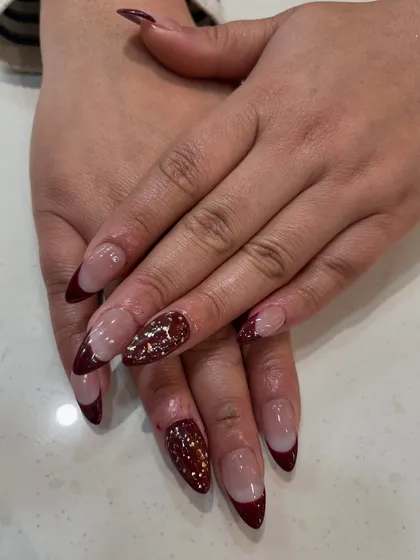 Perfect for a festive occasion or just because you love to sparkle. This look features a modern French manicure with a deep maroon tip and a full-coverage glitter accent nail for a touch of drama.