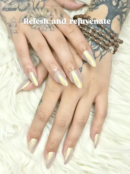 These stiletto nail extensions feature a stunning iridescent chrome finish that shifts in the light. This trendy and eye-catching look is perfect for anyone wanting a modern and high-fashion style.