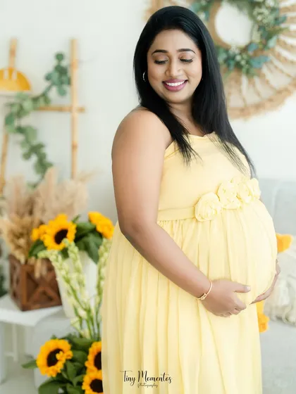 A joyful, candid-style shot that captures a beautiful, natural smile. The sunflowers and boho decor add a touch of rustic charm.