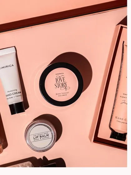 A detailed close-up of products from a beauty gift set, focusing on the textures of the body yogurt and hand cream. Macro shots like this highlight the quality and feel of the products.