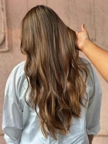 The back view of this 'Mochaccino' balayage. The long, flowing waves showcase the beautiful blend of light brown and caramel tones.