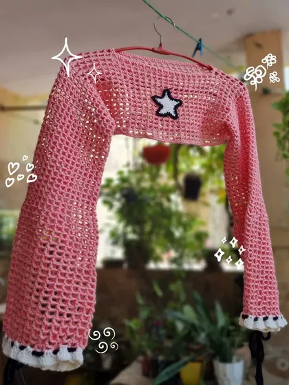 A closer look at our pink mesh bolero crop top. The star patch and ruffled details on the cuffs make this a fun and trendy piece to layer over your favorite top or dress.